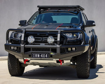 IRONMAN 4x4 APEX bull bar fitted to a black Ford Ranger Raptor with driving lights, front view