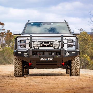 IRONMAN 4x4 Deluxe bull bar with driving lights fitted to a BYD Shark 6 on a gravel road