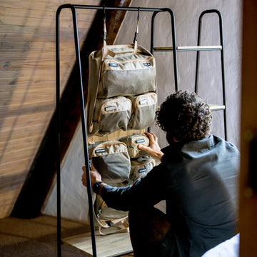 Man hanging an XPLR Duffel modular travel bag on a rack