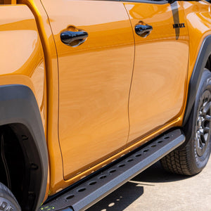 IRONMAN 4x4 premium side steps on an orange Toyota Hilux Travo, side view