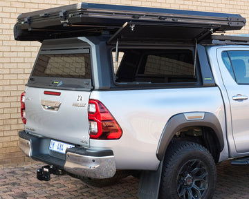 RAID Hybrid canopy on a silver Toyota Hilux GD-6 with side door open, rear three-quarter view