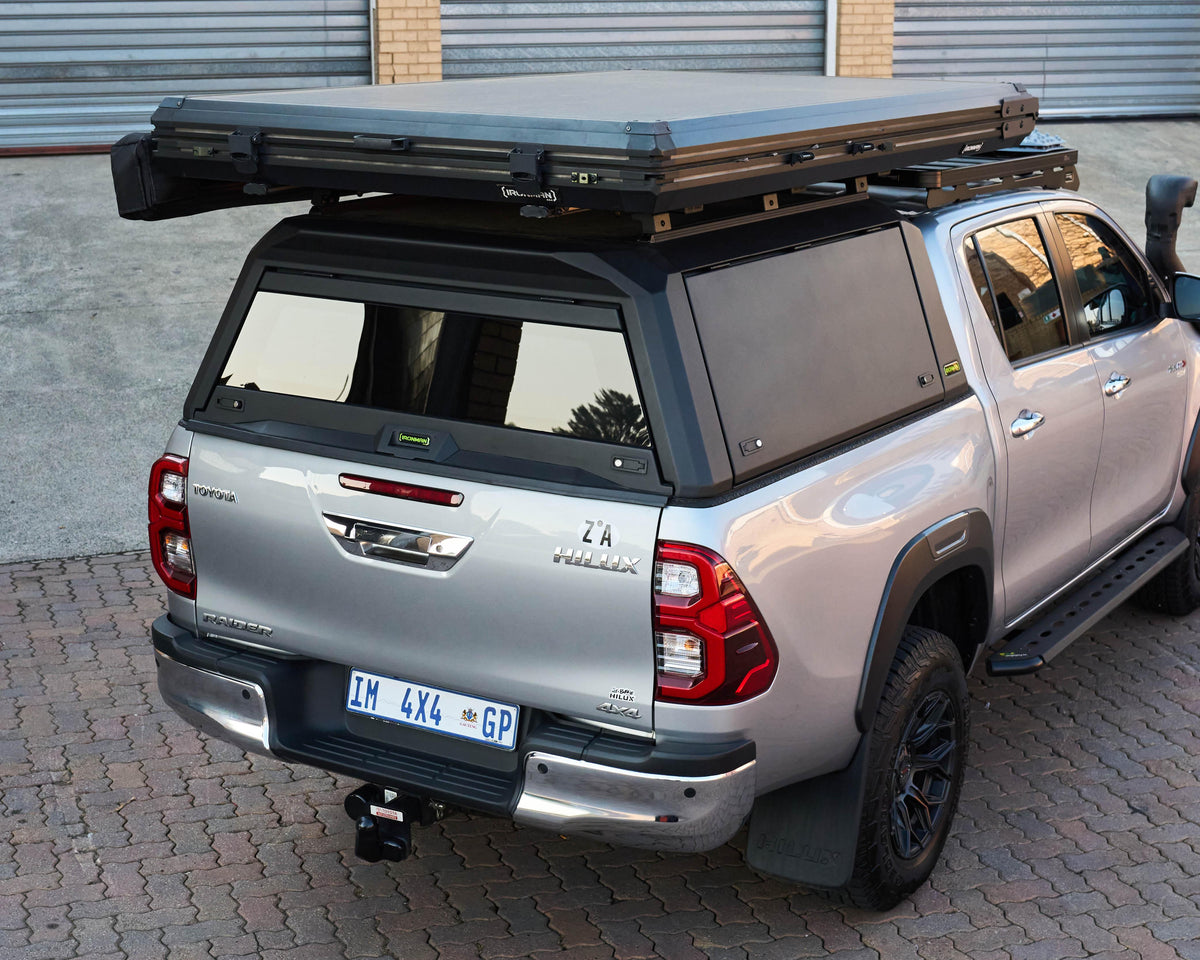 RAID Hybrid canopy on a silver Toyota Hilux GD-6 with rooftop tent, rear view