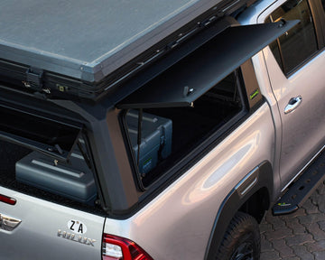 Close-up of the open side door on a RAID Hybrid canopy on a silver Toyota Hilux GD-6