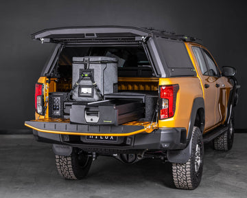 Orange Toyota Hilux with IRONMAN 4x4 mixed height drawers and a fridge in the canopy