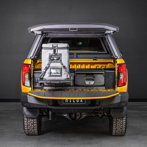 Orange Toyota Hilux canopy open, showing IRONMAN 4x4 drawers and a fridge on the slide