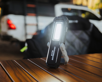 IRONMAN 4x4 rechargeable LED worklight standing on a table at camp