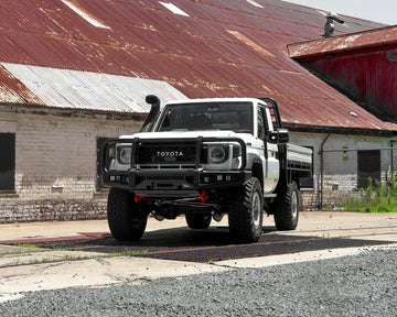IRONMAN 4x4 APEX bull bar fitted to a white Toyota Land Cruiser 79 single cab outside a shed