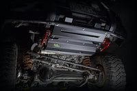 IRONMAN 4x4 underbody protection plates fitted under a vehicle, lit on a black background
