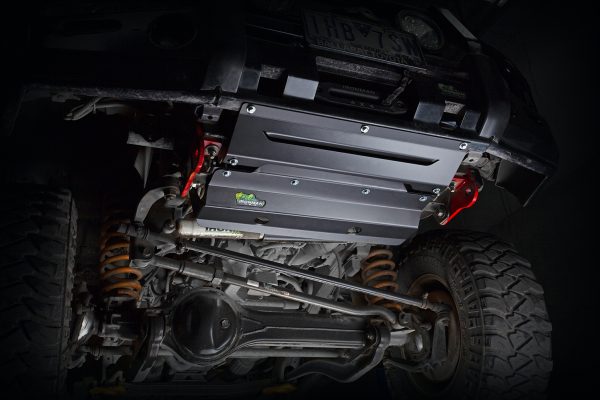 IRONMAN 4x4 underbody protection plates fitted under a vehicle, lit on a black background