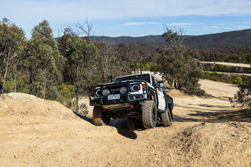 Toyota Land Cruiser with IRONMAN 4x4 APEX bull bar climbing a steep dirt track