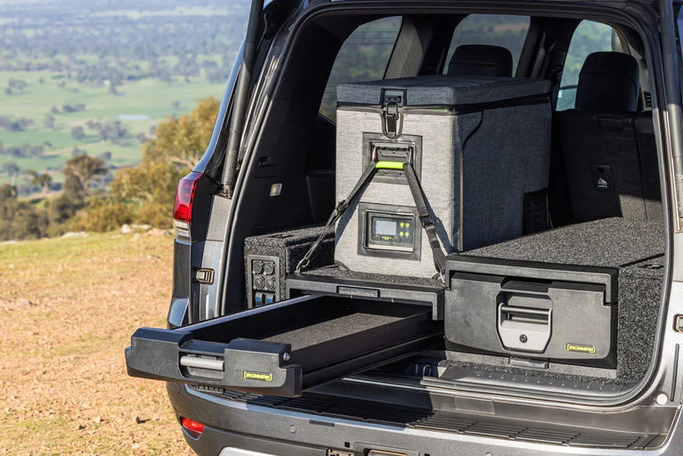 IRONMAN 4x4 roller drawer open with a fridge on the slide, fitted in an SUV parked outdoors