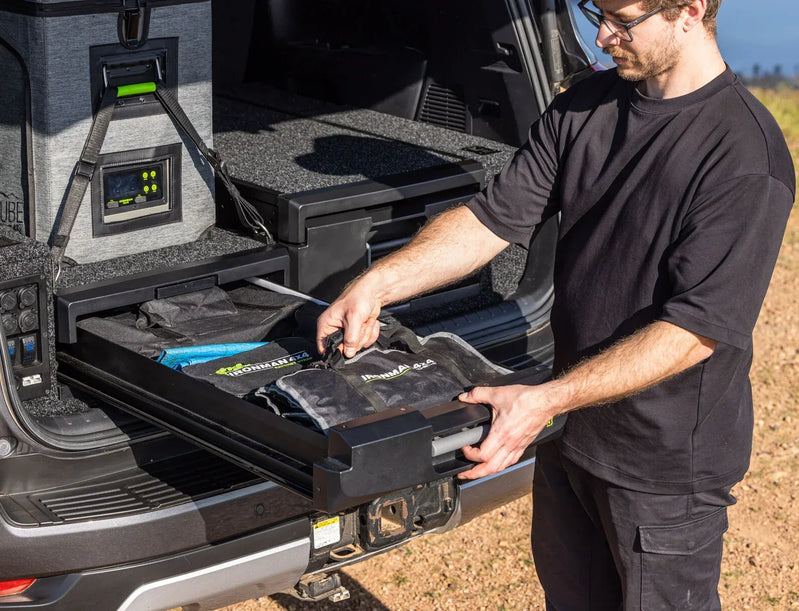 Loading gear onto an IRONMAN 4x4 roller drawer slide in the back of an SUV