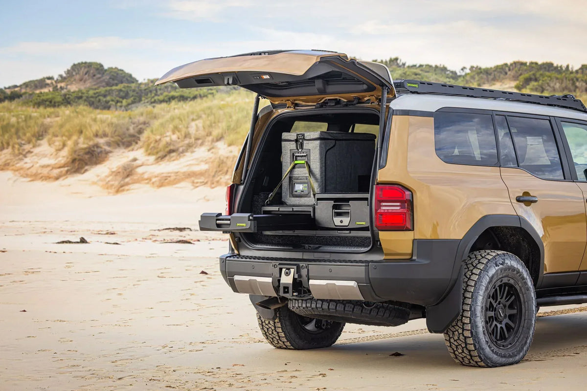 Toyota Prado 250 on the beach with tailgate open, showing IRONMAN 4x4 full height drawers