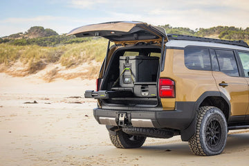 Toyota Prado 250 on the beach with tailgate open, showing IRONMAN 4x4 full height drawers