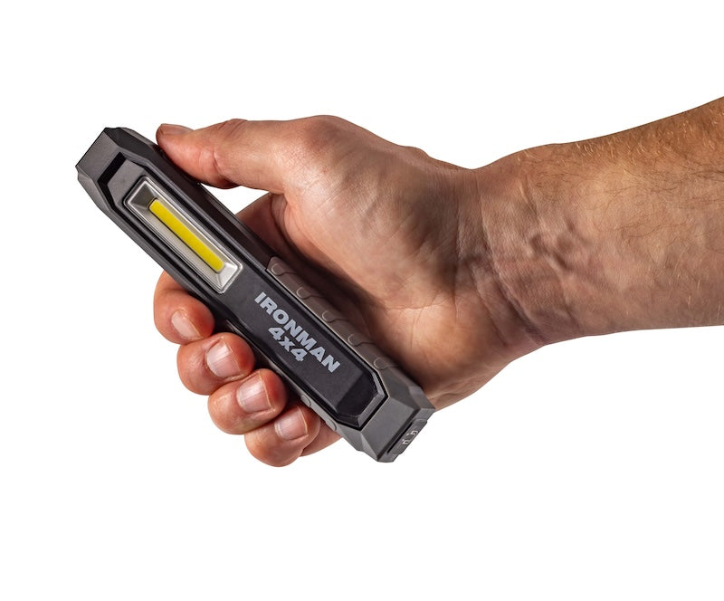 Hand holding the IRONMAN 4x4 rechargeable LED worklight combo, close-up