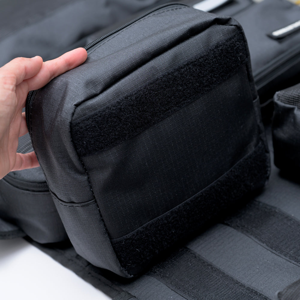 Hand removing a Velcro pouch from the XPLR Duffel travel bag