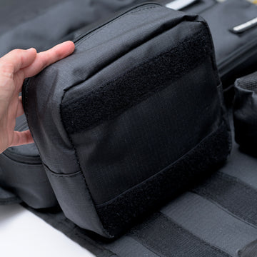 Hand removing a Velcro pouch from the XPLR Duffel travel bag
