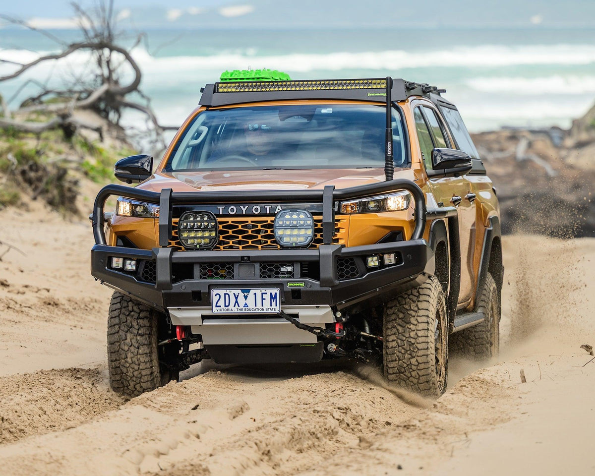 IRONMAN 4x4 APEX bull bar fitted to a Toyota Hilux Travo driving through sand