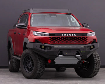 IRONMAN 4x4 RAID MKII bull bar fitted to a red Toyota Hilux Travo, front three-quarter view