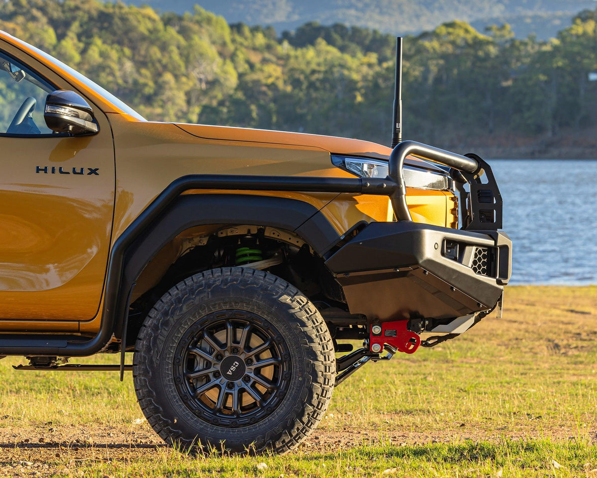 IRONMAN 4x4 APEX bull bar fitted to an orange Toyota Hilux Travo by a lake