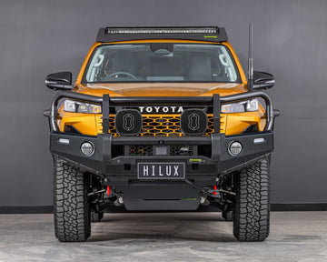 IRONMAN 4x4 Deluxe bull bar fitted to an orange Toyota Hilux Travo, front view