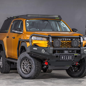 IRONMAN 4x4 Deluxe bull bar fitted to an orange Toyota Hilux Travo, front three-quarter view